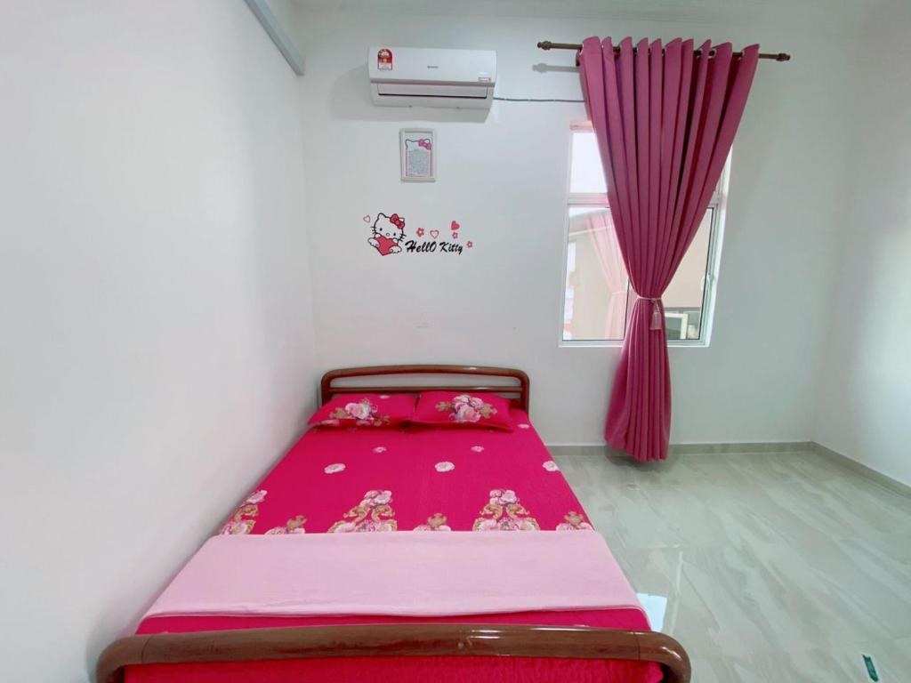 a bed in a room with a pink blanket at Roomstay HELLOKITTY HOUSE in Kuala Terengganu
