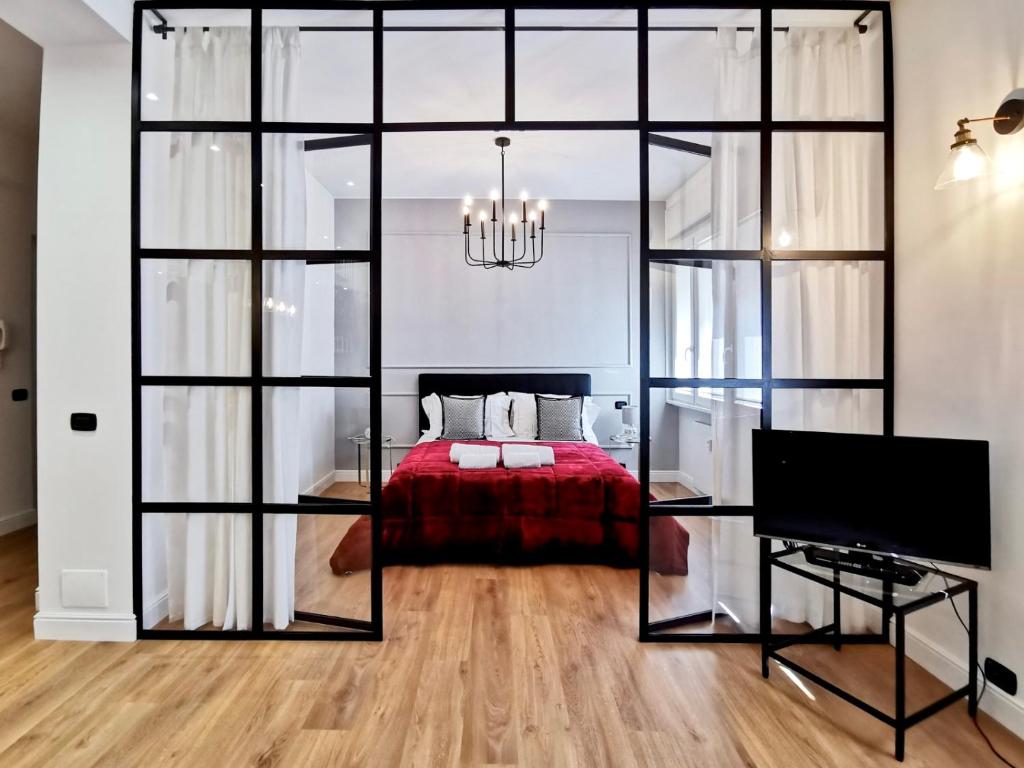 1 dormitorio con cama roja y TV en F L O R E N T I N Design Apartment ChicLife, en Bérgamo