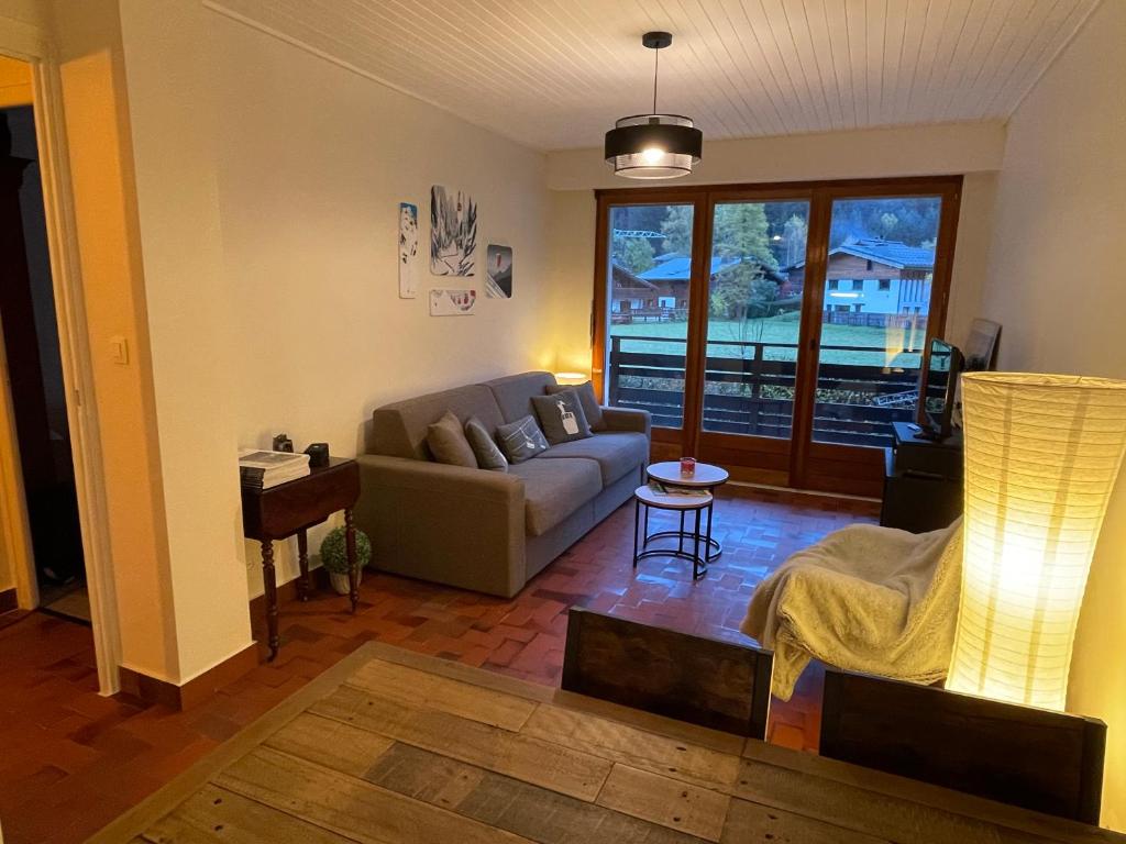 un salon avec un canapé et une table dans l'établissement Résidence Bois du Bouchet, appartement vue montagne, calme, parking gratuit, proche centre, à Chamonix-Mont-Blanc
