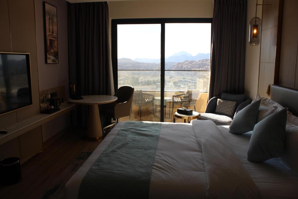 a hotel room with a large bed and a large window at H Luxury Hotel in Wadi Musa
