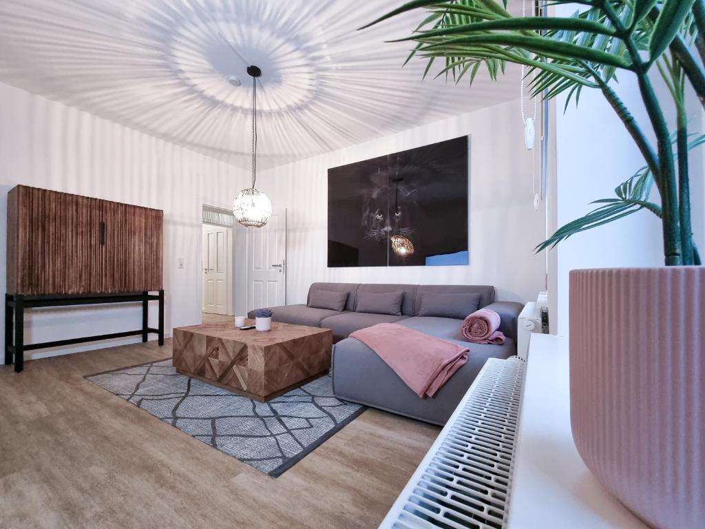 een woonkamer met een bank en een tafel bij Alpha Apartments in Dortmund