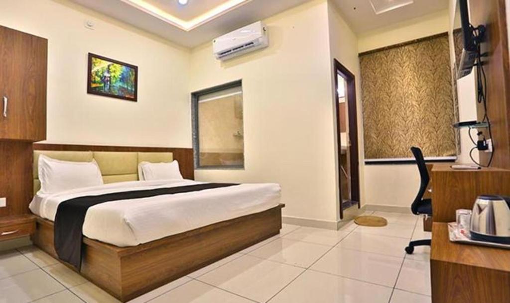 1 dormitorio con 1 cama grande en una habitación en FabHotel Prime Shree Dev Prime en Udaipur