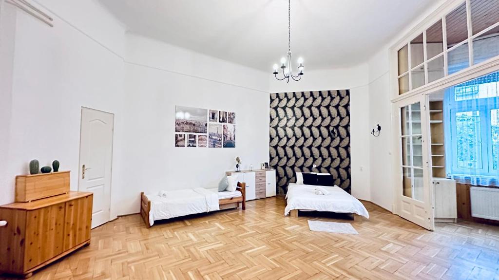 Habitación blanca con 2 camas y suelo de madera. en Ulloi Apartment - Unique Style near Corvin, en Budapest