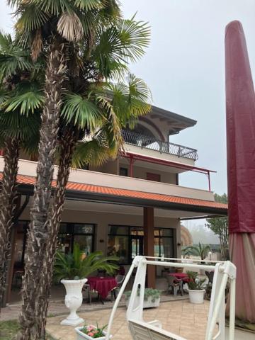 une maison avec des palmiers devant elle dans l'établissement Hotel Rey's, à Montegrotto Terme