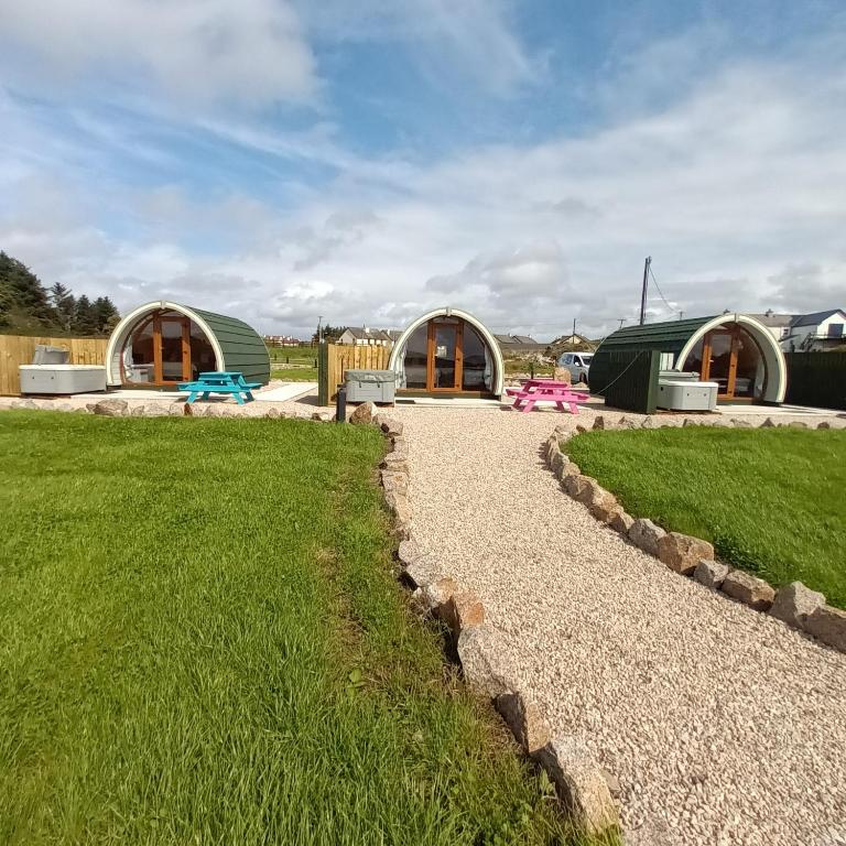 un sentiero di ghiaia di fronte a due edifici a cupola di Wheelhousepods glamping a Donegal