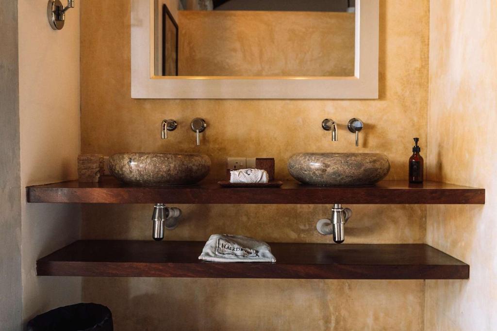 two sinks on a wooden shelf in a bathroom at Eraeliya Villas & Gardens in Weligama