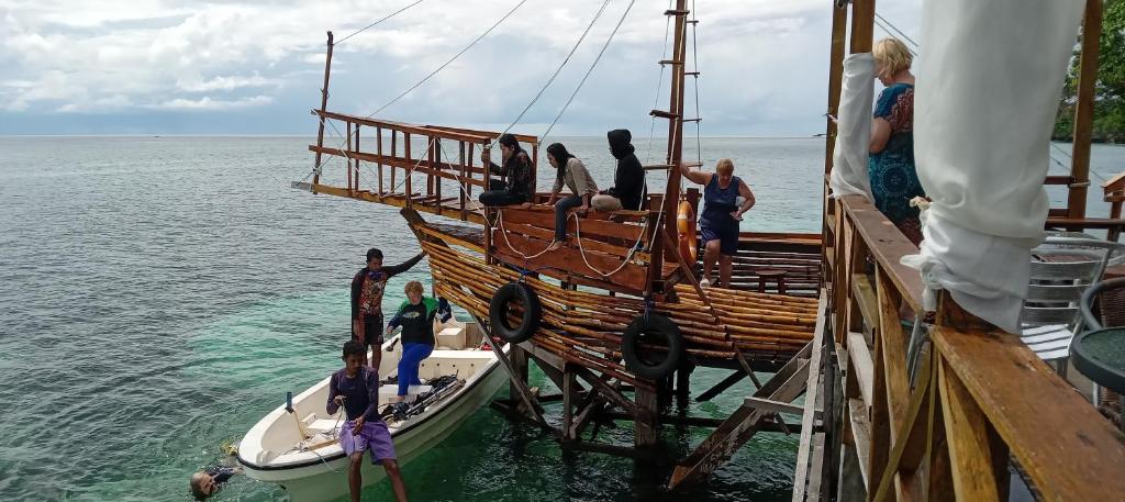 a group of people standing on a boat on the water at Nua Indah Hotel & Resto Wakatobi in Wanci