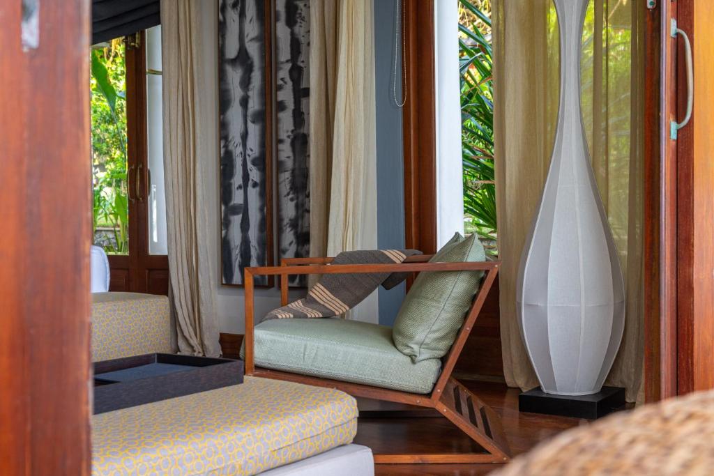 a living room with a chair and a vase at Eraeliya Villas & Gardens in Weligama