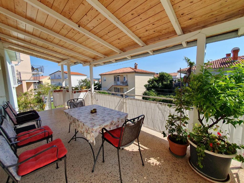 eine Terrasse mit einem Tisch und Stühlen auf dem Balkon in der Unterkunft SANDRA A4, 80 m FROM THE BEACH in Novigrad Istria