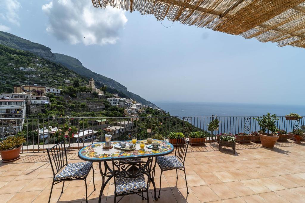 un tavolo e sedie su un balcone con vista di Casa Melevyen in Positano a Positano