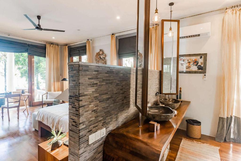 a bathroom with a brick wall and a sink in a room at Eraeliya Villas & Gardens in Weligama