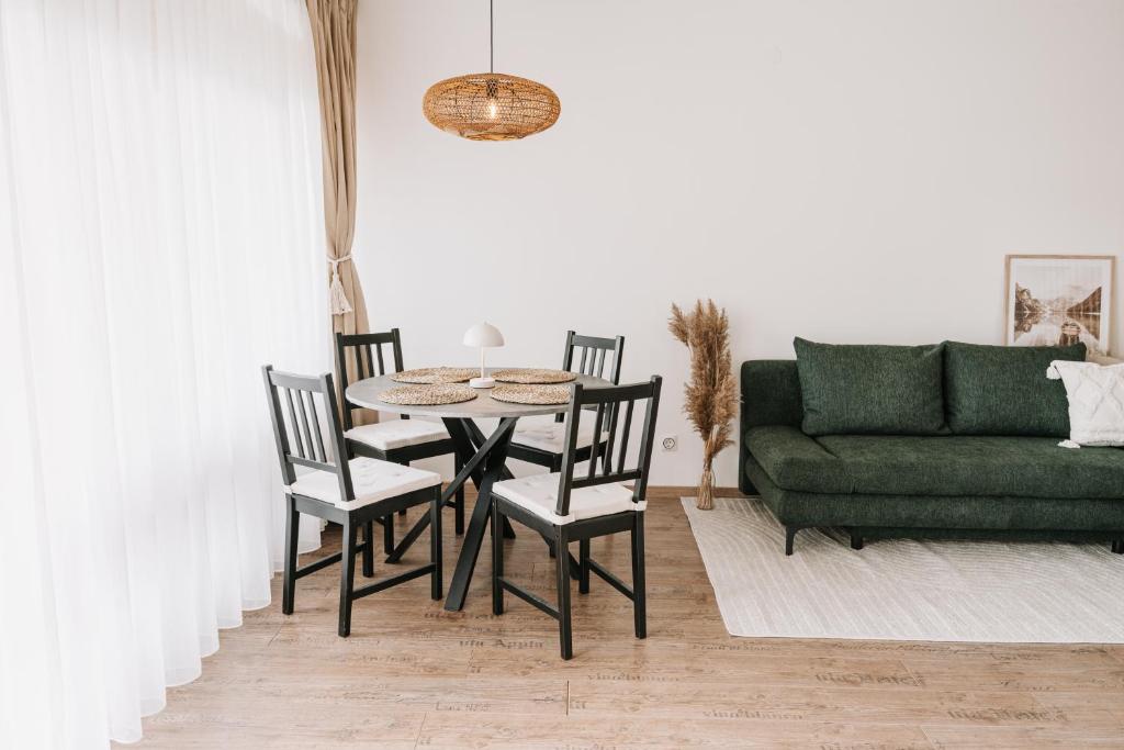 - un salon avec une table, des chaises et un canapé dans l'établissement Kleine Seezeit, à Purbach am Neusiedlersee