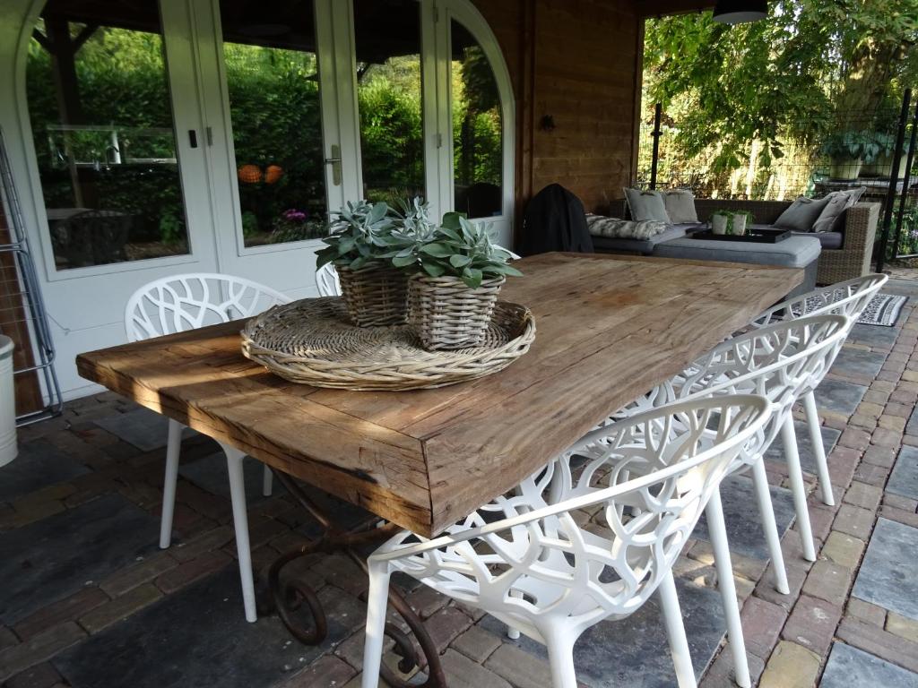 una mesa de madera con 2 sillas y 2 plantas. en Forest Villa, Kaatsheuvel, en Loon op Zand