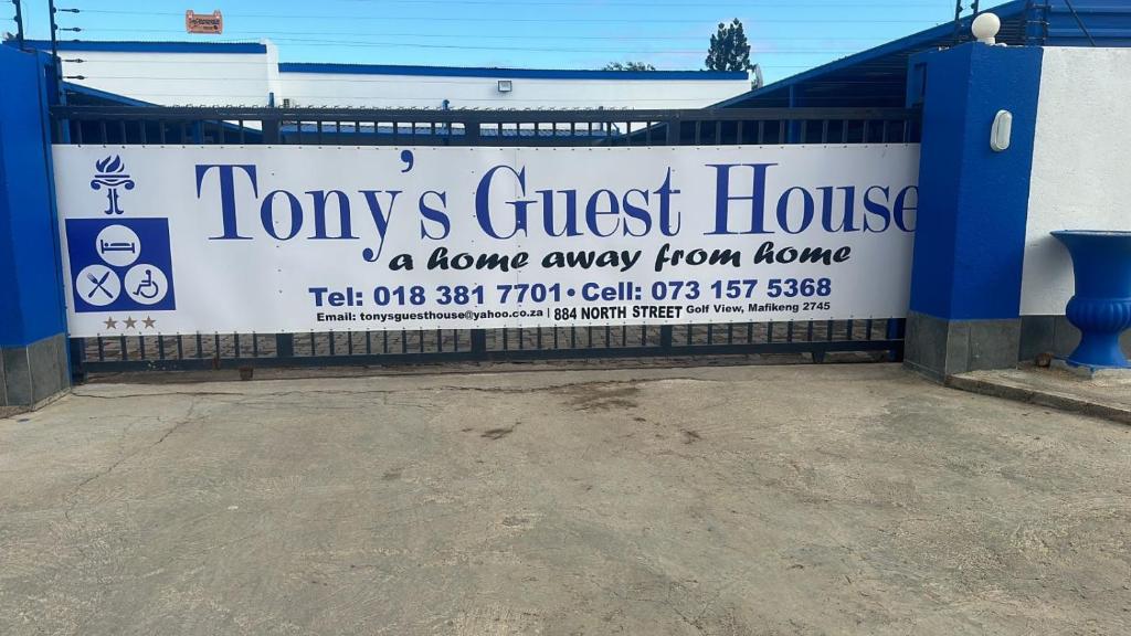 una señal de un hogar lejos de casa en una valla en TONY'S GUEST HOUSE 2 en Mahikeng