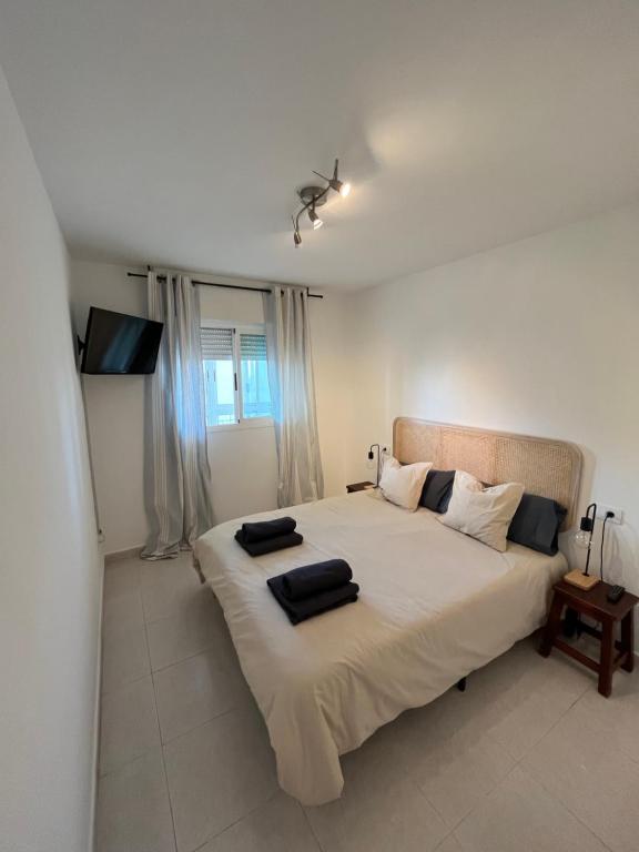 1 dormitorio con 1 cama grande y 2 almohadas en APTO RESIDENCIAL EN BENICASIM en Benicàssim