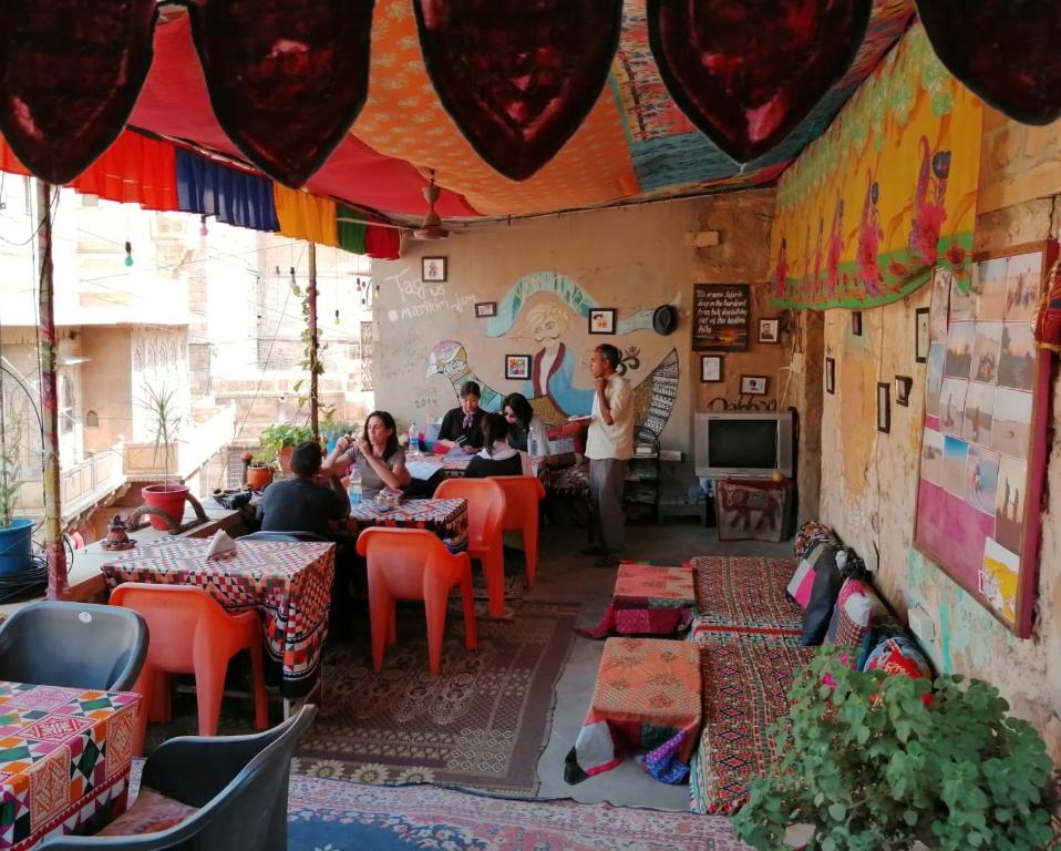 um grupo de pessoas sentadas em mesas em um restaurante em Marigold Homestay em Jaisalmer