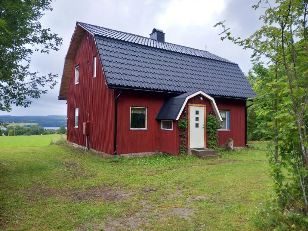 un granero rojo en la parte superior de un campo en Daltorp - äldre, charmigt hus på landet, en Brunflo