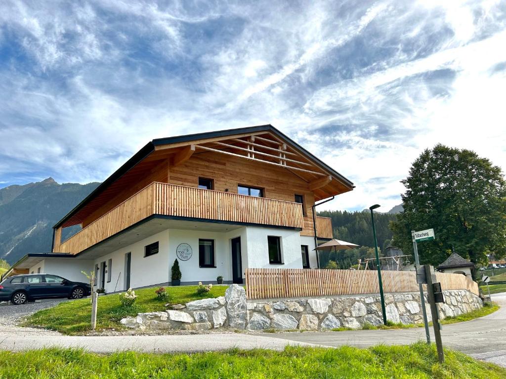 a house with a wooden roof on top of it at Mei-so-nett Appartement Hutegger in Schladming