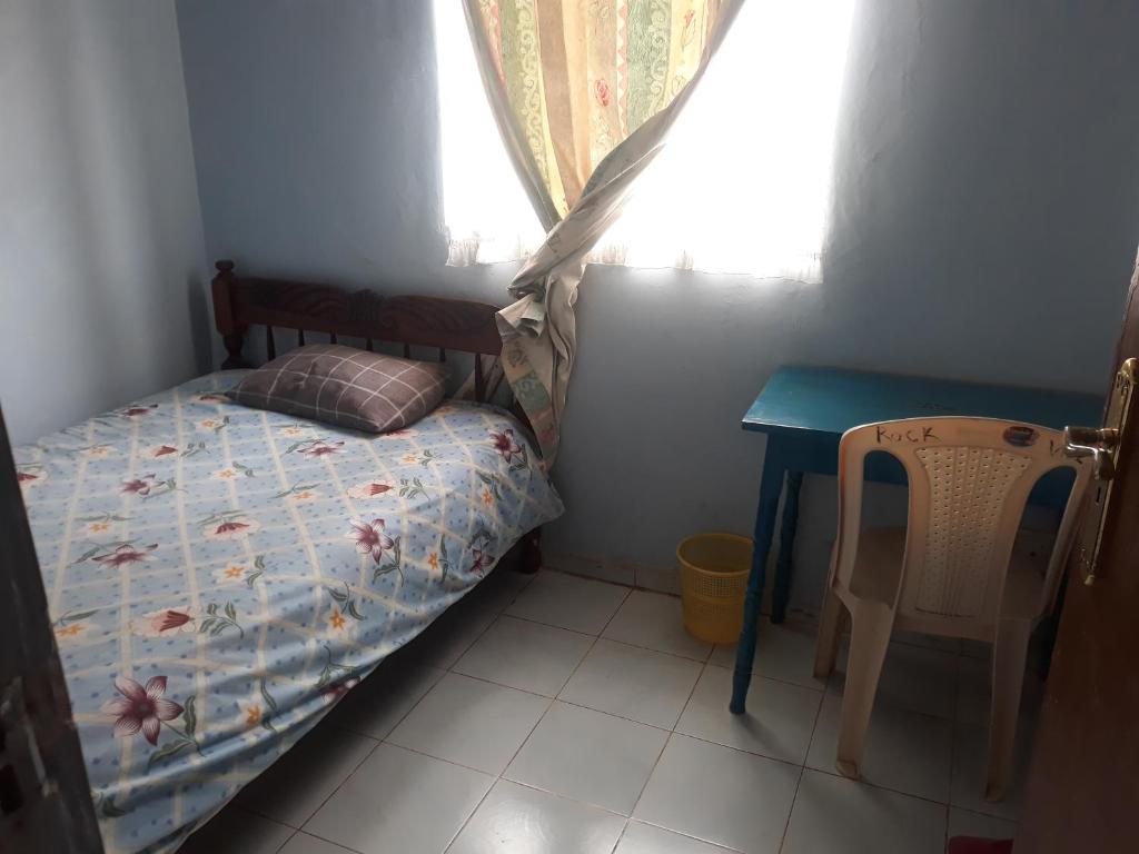 a small bedroom with a bed and a table at RockVilla GuestHouse Njabini SouthKinangop Nyandarua in South Kinangop