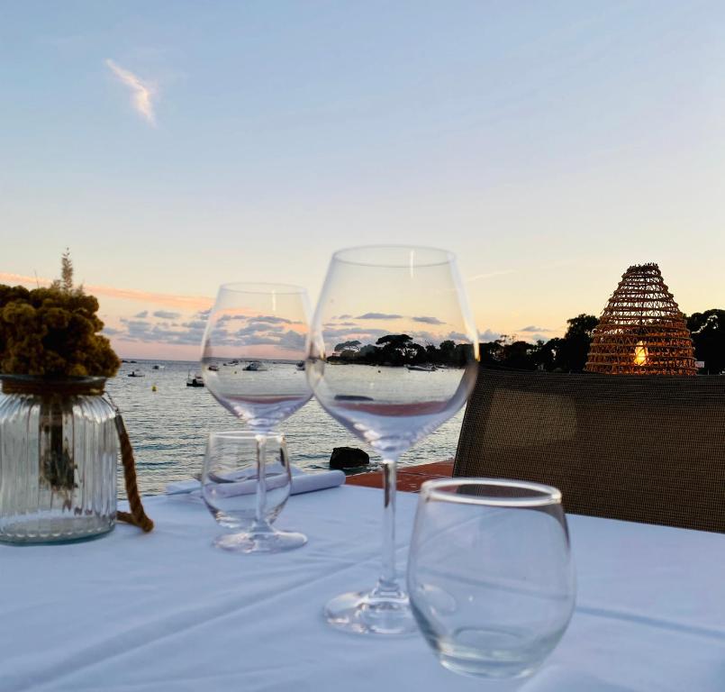 three wine glasses sitting on a table near the water at Palm Beach in Ajaccio