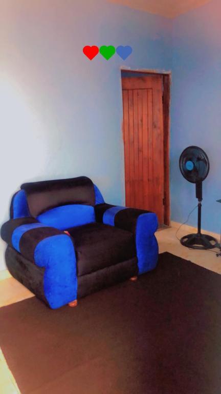 eine blaue und schwarze Couch in einem Zimmer mit Tür in der Unterkunft K House in Kampala