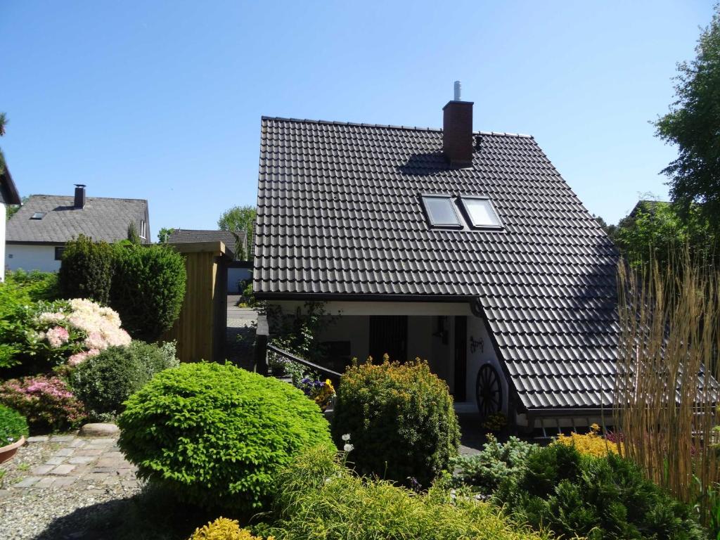 a house with a black roof and some bushes at Ferienhaus Urlaub am Meer in Maasholm-Bad