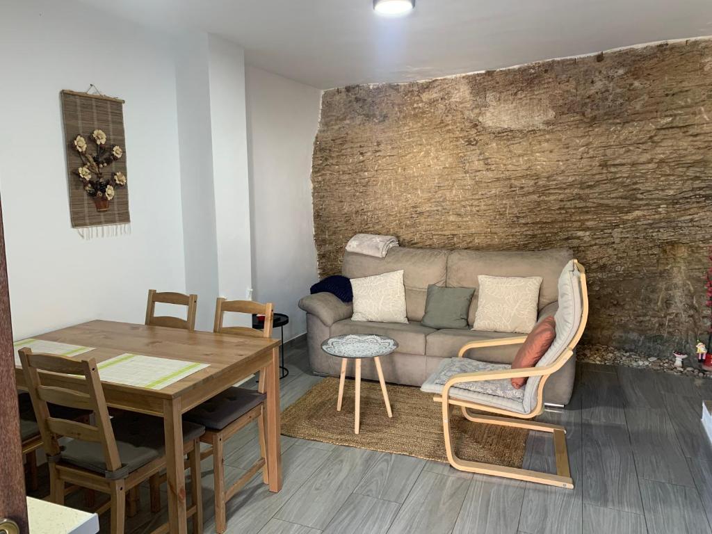 - un salon avec un canapé et une table dans l'établissement Casita en el Tajo, à Setenil de las Bodegas