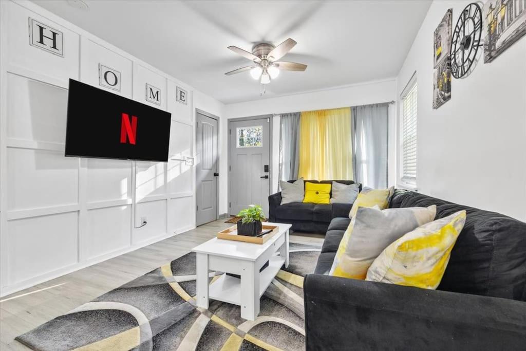 a living room with a black couch and a tv at NEW! Modern Comforts w/ 4Beds/3BR Sleeps 8 in Atlanta