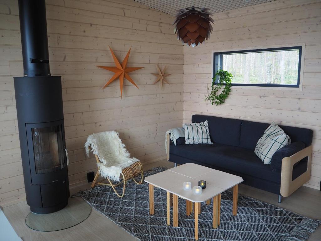 een woonkamer met een bank en een fornuis bij Scandinavian lakeside cottage in Rovaniemi