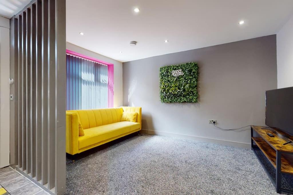 a yellow couch in a room with a tv at Neat Retreat Graig Pontypridd in Pontypridd