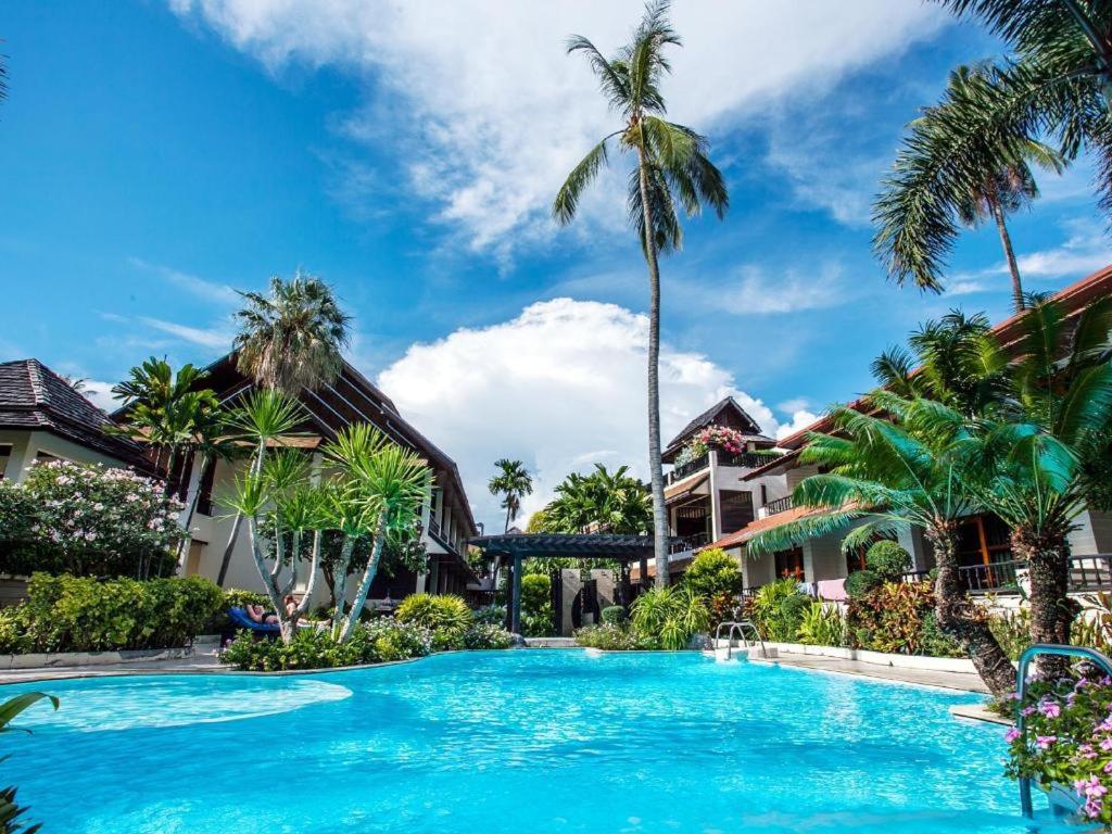 a swimming pool in a resort with palm trees at Phi Phi Banyan Villa in Phi Phi Don