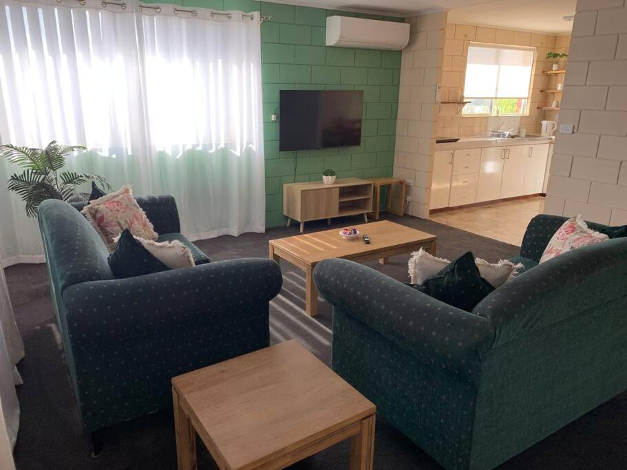 a living room with two blue chairs and a television at Harbour View 49 Urch Street Unit 2 in Geraldton