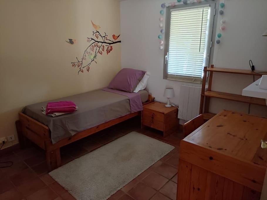 een kleine slaapkamer met een bed en een raam bij Cosy rez-de-jardin de villa in Brignoles