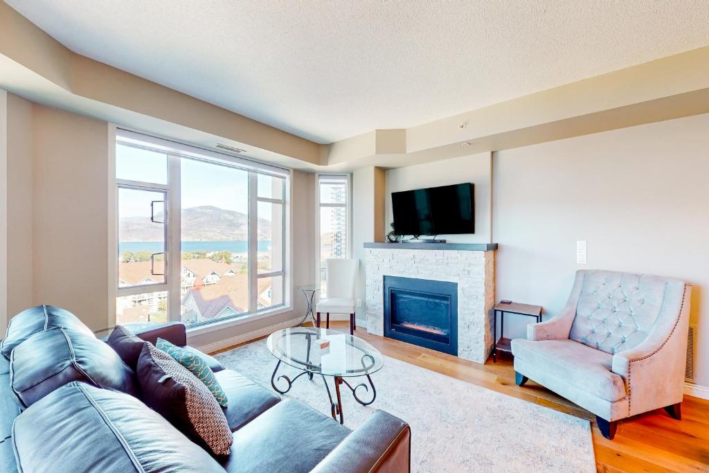 a living room with a couch and a fireplace at Sunset Waterfront Resort #1306 in Kelowna