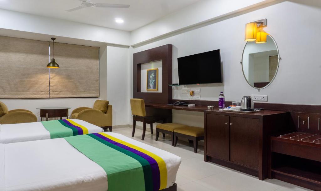 a hotel room with a bed and a desk at Treebo Trend Bhairavee in Pune