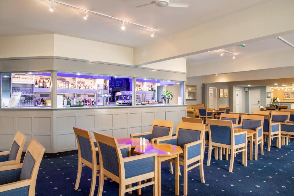 um restaurante com mesas e cadeiras e um bar em Tiverton Hotel Lounge & Venue formally Best Western em Tiverton
