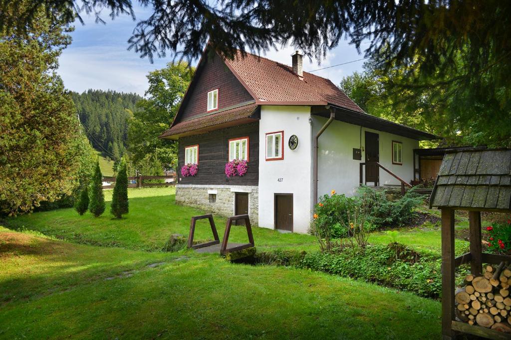 uma pequena casa com flores cor-de-rosa ao lado em Karolinka Holiday Homes em Karolinka