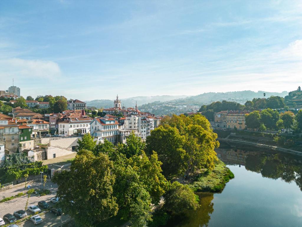 a view of a city with a river and buildings at Casa do Fontanário Stay in Amarante