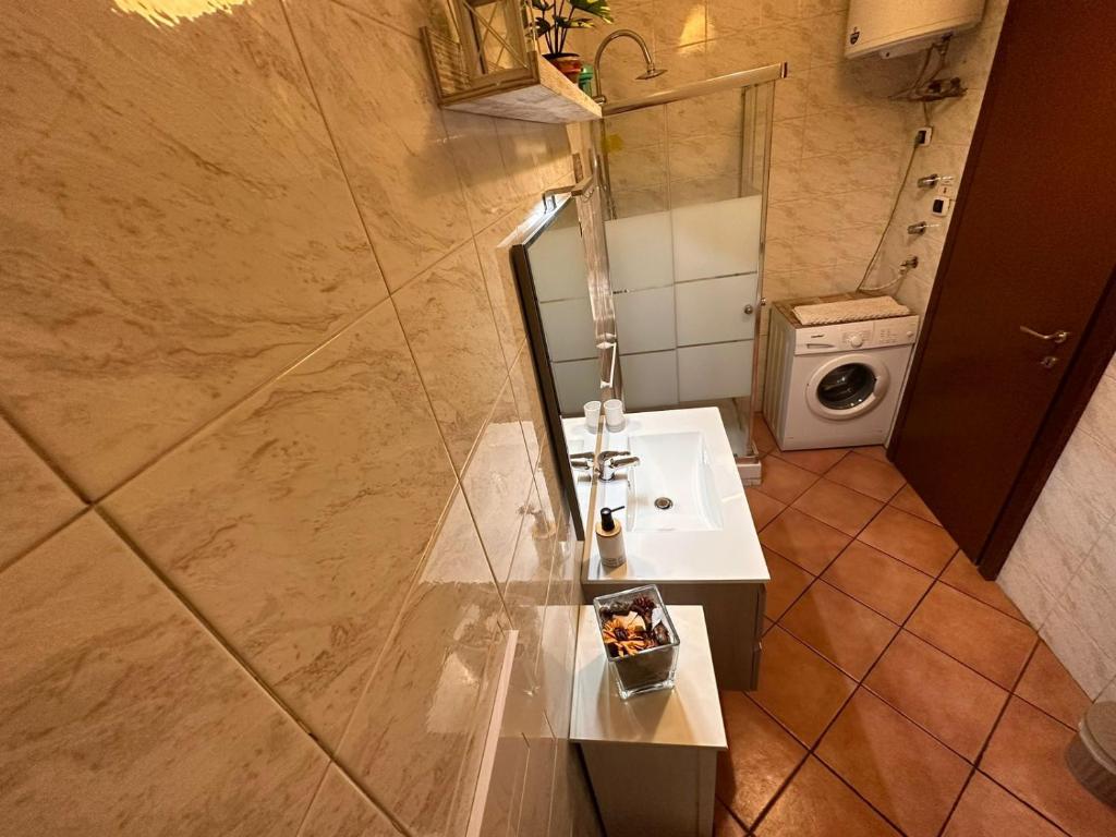 a bathroom with a sink and a washing machine at Ricomincio Da Qui in Naples