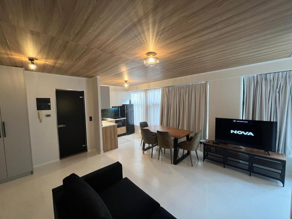 - un salon avec un canapé et une table avec une télévision dans l'établissement Modern Downtown apartment + FREE parking, à Larissa