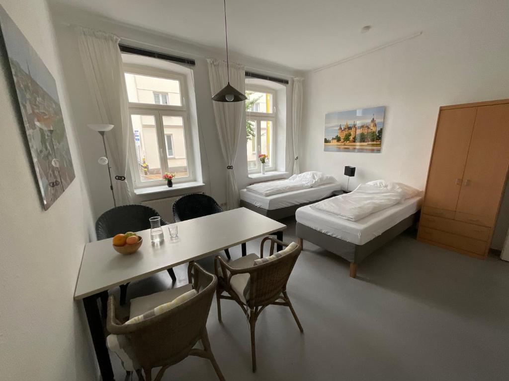 a living room with a table and a bed and a room at Fewo Berta in Schwerin