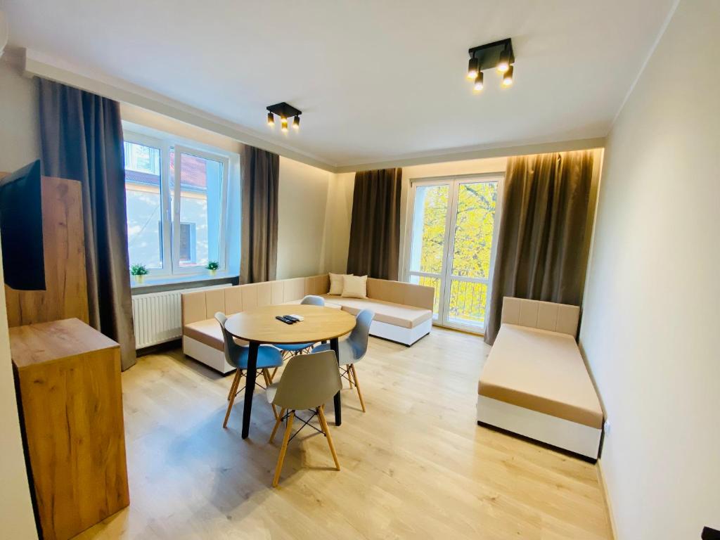 una pequeña sala de estar con mesa y sillas. en Gold Apartament, en Świdnik