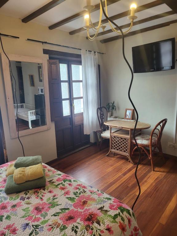1 dormitorio con cama, mesa y TV en el BOSQUE MAGICO, en Piñeres