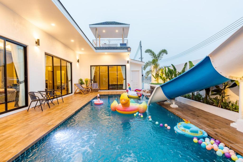 uma piscina com escorrega insuflável numa casa em PP POOL VILLA @ CHA-AM (ทรัพย์เพิ่มพูนพูลวิลล่า) em Ban Hup Kaphong