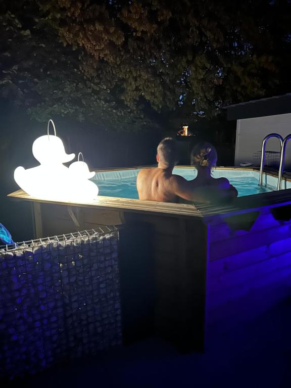 un hombre y una mujer en una bañera por la noche en Cosy@Beauty, en Petit-Rechain