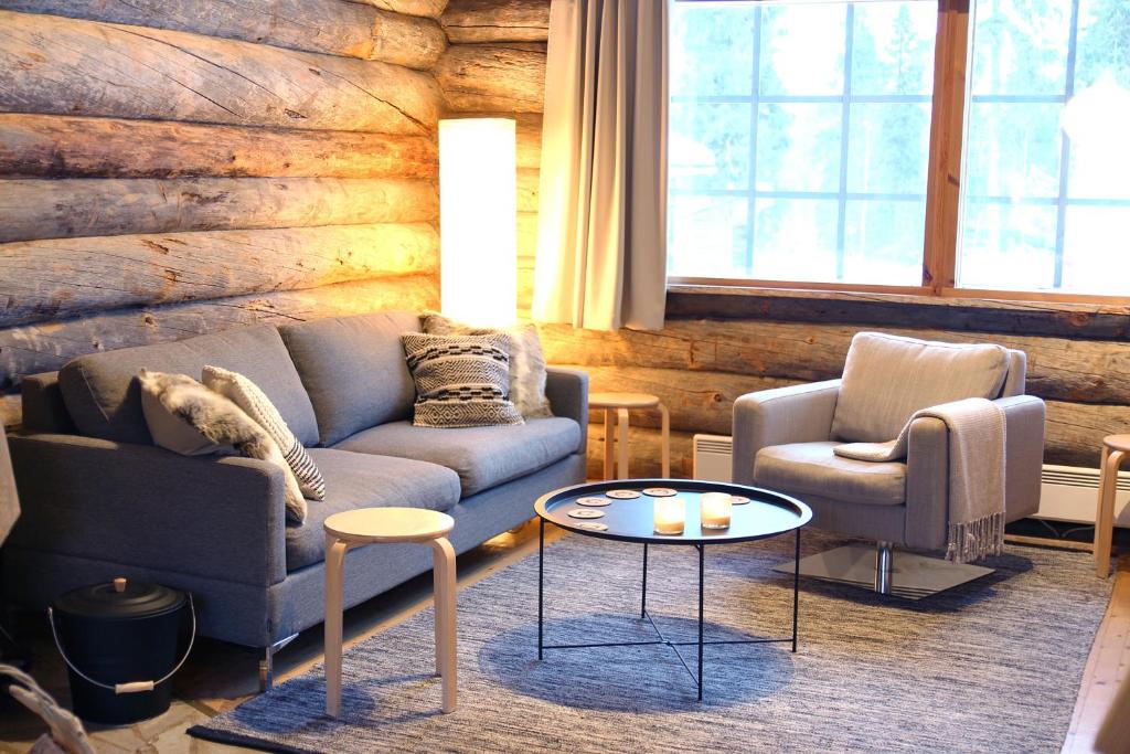 sala de estar con sofá, 2 sillas y mesa en Lapland Cabin Vonkamies, en Luosto
