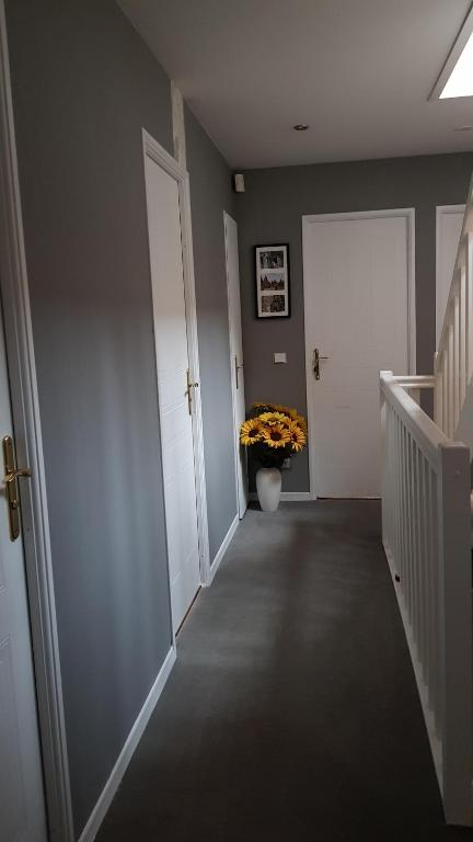 a hallway with a vase of flowers in a pot at Chez Laurence &amp; RV in Vauréal