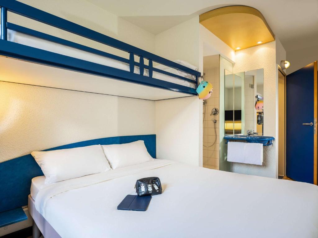 una habitación de hotel con una cama con reloj en Ibis Budget Graz City, en Graz