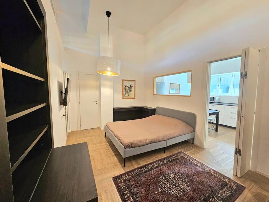 een slaapkamer met een bed en een tafel in een kamer bij Grazioso bilocale ristrutturato vicino alla Stazione/metro in Milaan