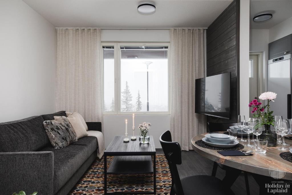 un soggiorno con divano e tavolo di Holiday in Lapland - Ylläs Polar Charm B a Ylläs